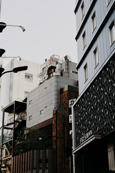 photo of some machinery looking like it belongs to industrial works, onm top of a small building in a narrow street