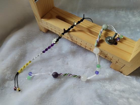 a bracelet with the non-binary pride flag palette and a bracelet with the genderqueer palette.