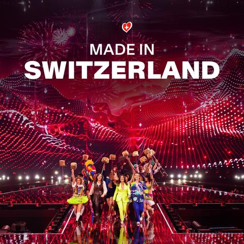 Cover der Single Made in Switzerland, zeigt ein Standbild der Show, die Sänger laufen mit übergrossen Fonduegabeln mit käsebedeckten Brotstücken über die glitzernde Bühne hinter Hazel, Sandra und Petra her