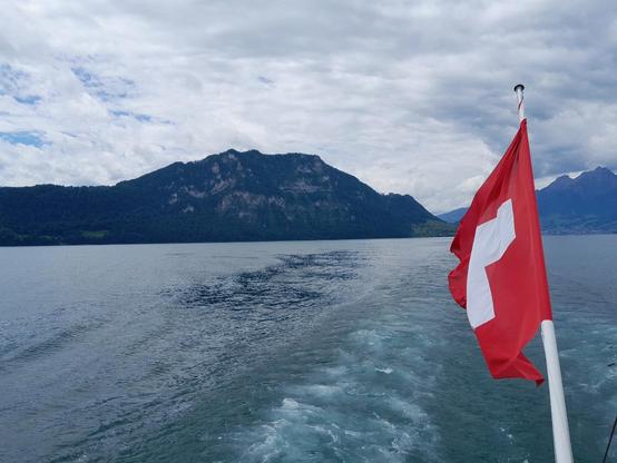 Blick vom Schiff auf den Berg Bürgerstock. Rechts ist eine Schweizerfahne zu sehen.