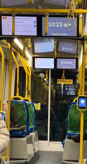 One overhead display in this tram says 10.23 AM. The other says 8.23 PM. It is dark outside.