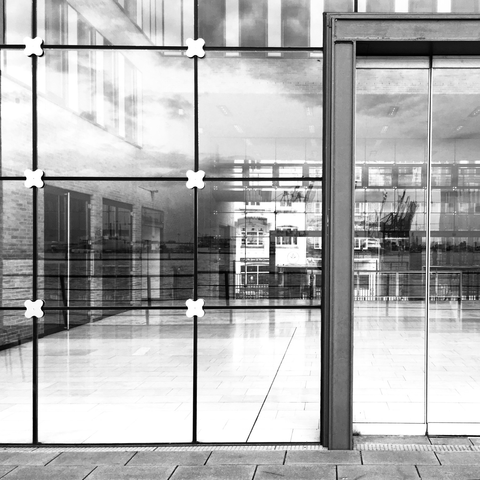 black and white photograph of hamburg reflected in a large window.