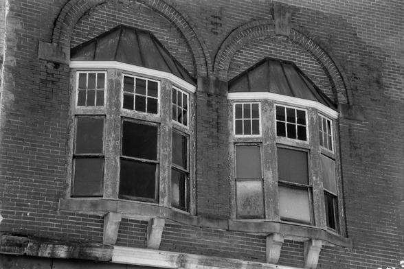 A set of two bay windows in an old, vacant building