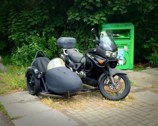 a sidecar motorcycle with dust on it on the side of a road