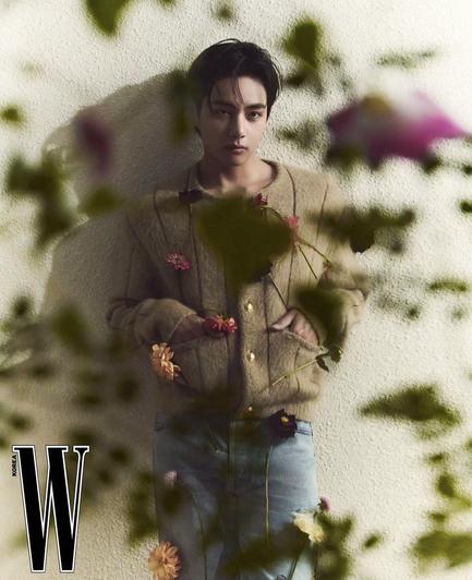 Taehyung for Celine in W Korea Magazine. Sweater and Jeans, shot with flowers and foliage in the foreground