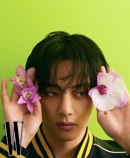 Taehyung for Celine in W Korea Magazine. Bright green flowers, holding pink flowers up to his head. Side-eye.