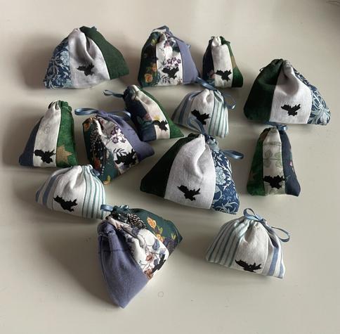 13 scent sachets in green, white, and blue fabric with a tiny logo printed on the white stripe.