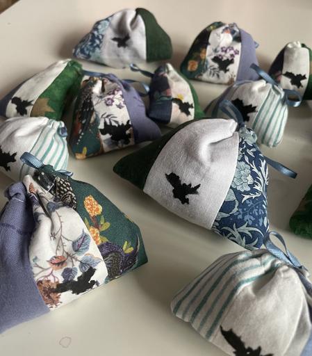 Closeup on some striped lavender sachets. Some are patterned fabric, and some are plain.