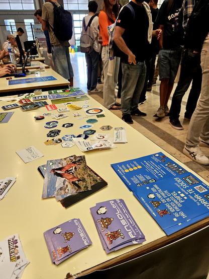 mesa com bastantes panfletos e autocolantes sobre software livre e a ANSOL - Associação Nacional para o Software Livre