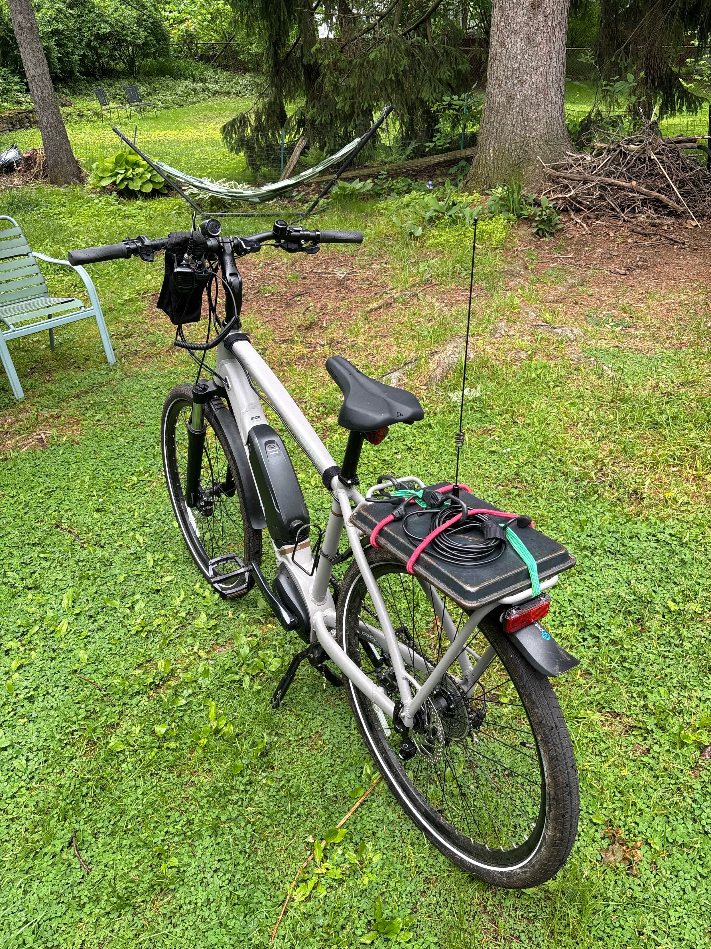 bike with magnetic mount 2 meter & 70 centimeter antenna on rear carrier & Yaesu HT w speaker/microphone in bag hanging from handlebars