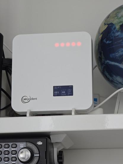 A photo of a white box with a small screen, it has the text "airgradient" on the front.