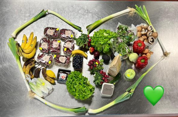 Die geretteten Lebensmittel sind in Herzform auf dem Tisch ausgebreitet