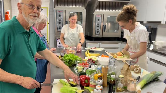 Fleißige Hände schnippeln die Zutaten für Salat, Suppe und Gemüsepfanne