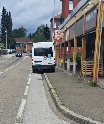 Un fourgon de livraison stationné sur une piste cyclable et sur un trottoir.