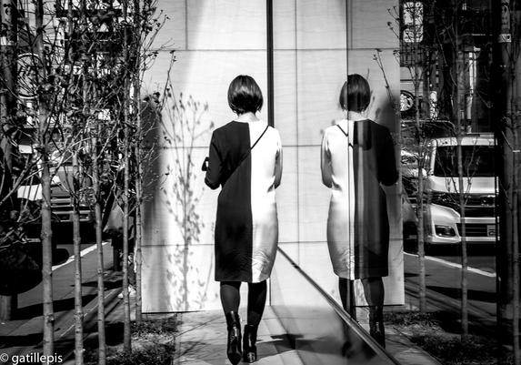 Reflex en un aparador d'una dona amb un vestit blanc i negre.