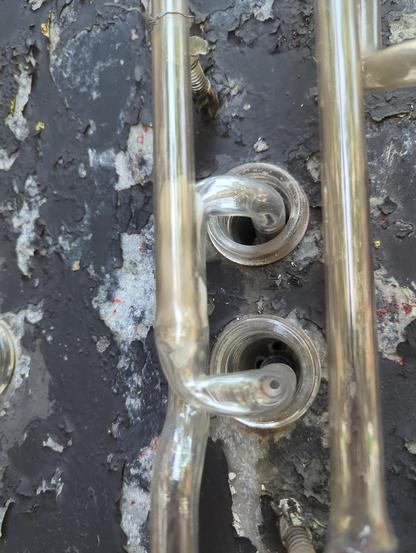 A Very Useful shot for me of the housing placement. The electrodes push into these springs sleeved in glass that send the neon's high voltage safely through the steel into the sign structure where all the transformers and wiring are. I have to hit these targets when I bend the glass. And since these patterns are tracings of decades of other peoples work and no templates exist, this photo will tell me a few mm here and there to nail the middle of both of the housings.