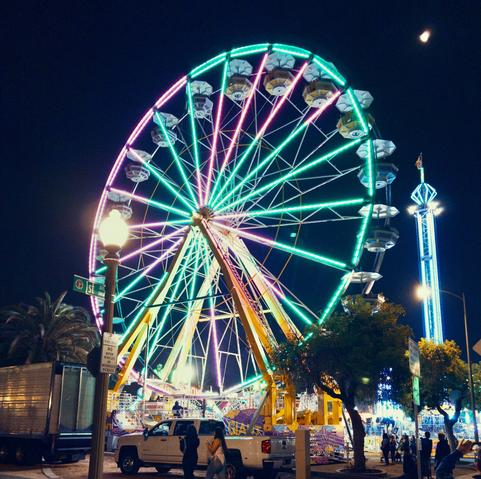 Night-time ferris wheel lit up in blues and purples.