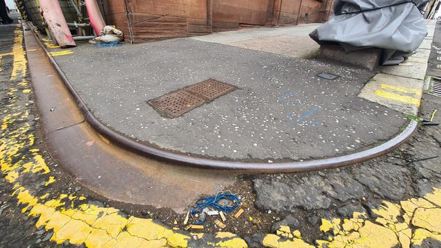 An old metal kerb protector on the corner of a Glasgow street.
