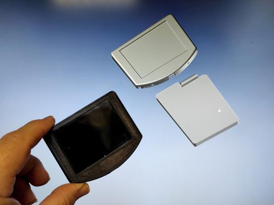 The first assembled Vijou display, 3D printed from black plastic, in front of the CAD screen with the complete design.