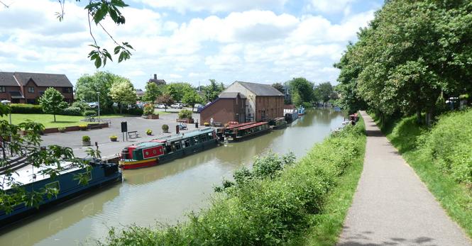 A canal wharf, with narrowboats moored.