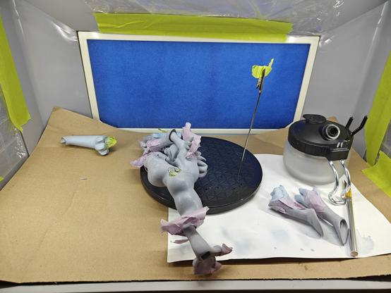 a haphazard array of 3d printed Renamon parts arranged in a spray booth with attempts to masking tape her parts
