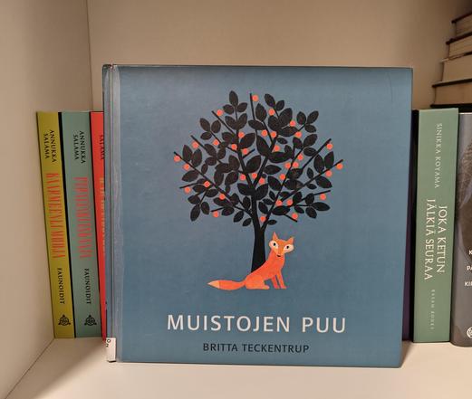 Kuvassa Muistojen puu -kirja kuvattuna kirjahyllyssä.