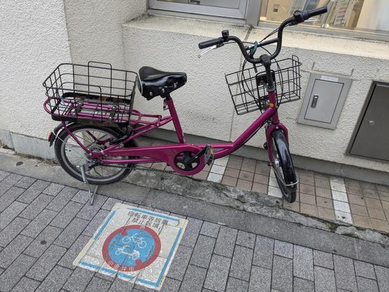 Ein falsch geparktes pinkes Fahrrad.