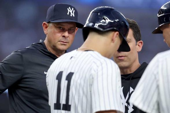 Yankees players and manager check Anthony Volpe after he got hit with pitch
