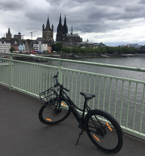 Schwarzes Sushibike auf der Deutzer Brücke. Im Hintergrund der Dom. Wolkenverhangener Himmel