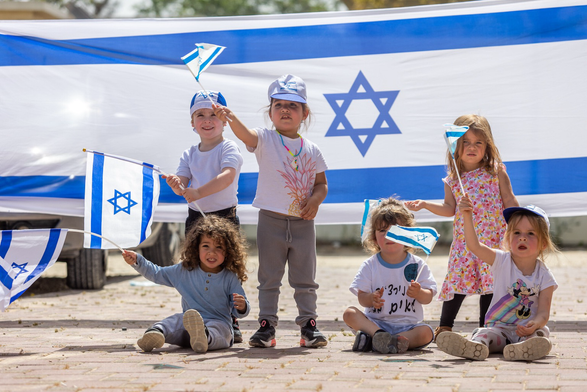 Happy healthy Israeli children waving flags
