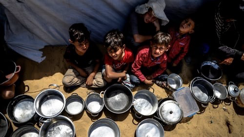 Starving Palestinian children holding empty food bowls
