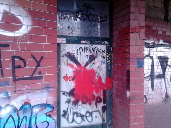 Tür an der Ruine des Ihmezentrums in Hannover-Linden, das Glas der Tür ist von innen zugeklebt, alles ist mit Graffiti übersät. Die Tür wurde seit Jahrzehnten nicht mehr benutzt.