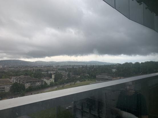 Blick vom Spitalzimmer Richtung Zürichsee. Regen und helle Wolkenlückwn wechseln sich ab.