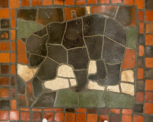 multicolor floor tile mosaic, side profile of a black bear, labeled “URSUS” and numbered “95”