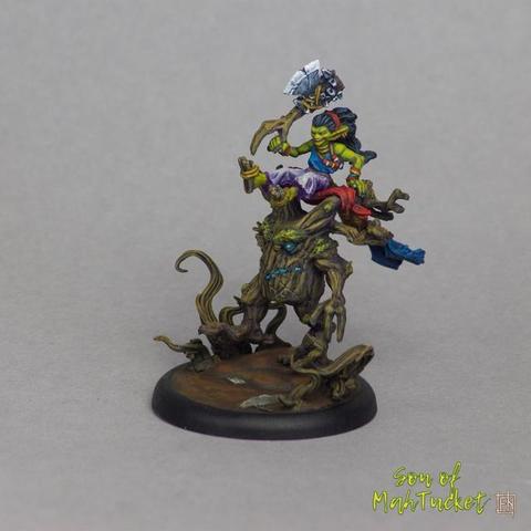 This image captures a beautifully hand-painted miniature that bursts with color, character, and narrative potential. At first glance, it depicts a goblin-like figure astride a small, animated tree-like creature—a fantastical mount that seems both ancient and mischievous. The contrast between the organic, earthy base and the dynamic, vibrant rider creates an instantly compelling composition, reminiscent of whimsical yet perilous forest adventures from old folklore or tabletop RPGs.