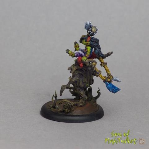 This rear three-quarter view of the miniature unveils an entirely different layer of character—almost cinematic in its drama. From this angle, the dynamic goblin rider appears regal and commanding, gazing forward as her mount strides defiantly onward. We’re no longer just witnessing whimsy and mischief, but purpose and presence. The details hidden from the front now come into full focus, revealing even more complexity and flair.