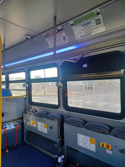 The interior of a CET bus, during the evening. The inside lights are on.