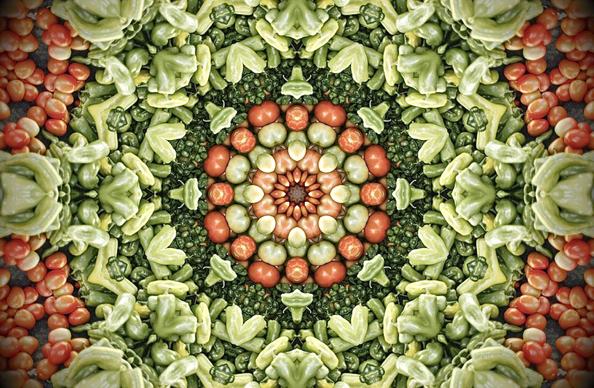 A radial kaleidoscope made from a photo of green peppers and red tomatoes. More tomatoes around the center and at the outside corners, but mostly green peppers.