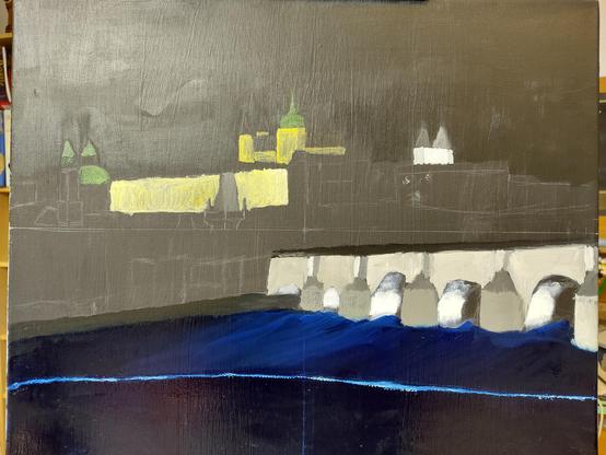 The beginnings of a painting of the Charles Bridge in Prague at night. The painting is in the block-in stage where base colors are being added. Some buildings in the background, the bridge, and water have color, other areas still need work.