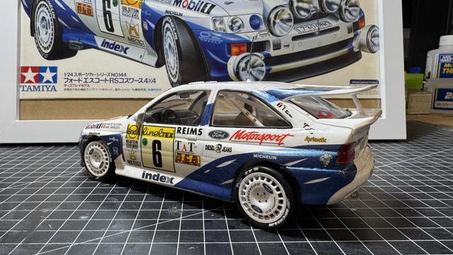 Finished model of a Ford Escort RS Cosworth by Tamiya in 1:24 on top of a workbench.
