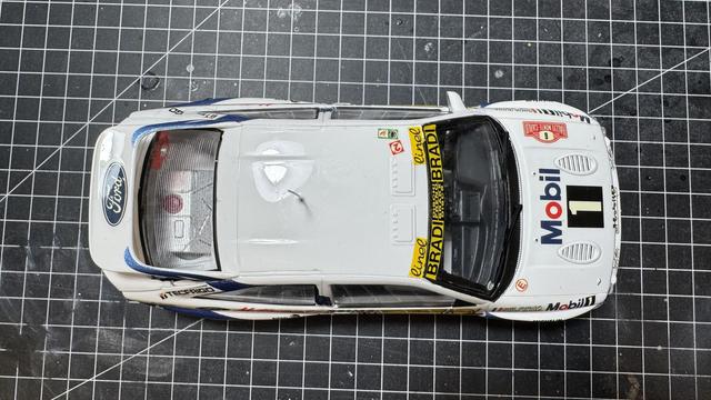 Finished model of a Ford Escort RS Cosworth by Tamiya in 1:24 on top of a workbench.