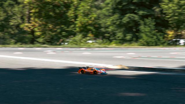 a panning shot of a 'prototype' style RC car on an on-road RC track