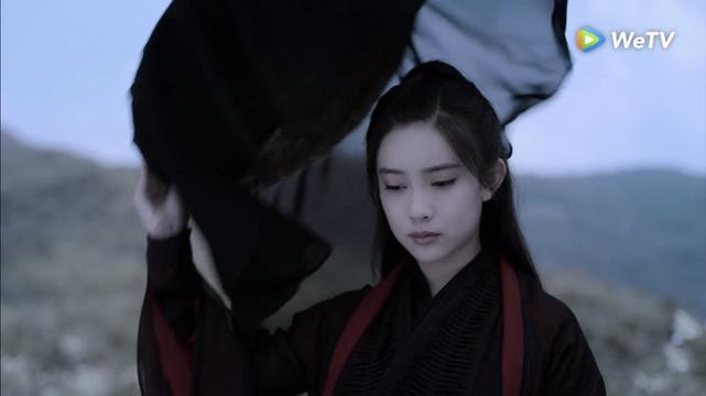 Wen Qing removes a veiled hait, revealing a solemn expression and downcast eyes.