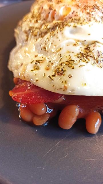 Baked Beans mit Bacon und Ei oben drauf
