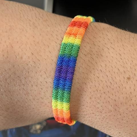 Foto de mi muñeca con una pulsera con los colores de la bandera arcoíris.