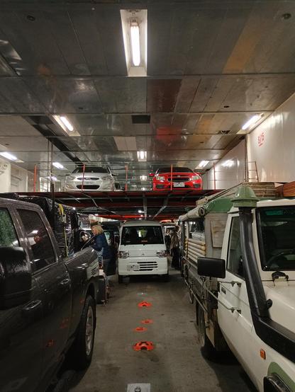 A very small EV in a giant car ferry surrounded by other cars