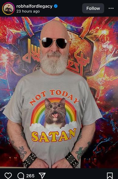 Rob Halford from Judas Priest wearing a shirt saying “Not Today Satan” with a cat looking out from a rainbow.