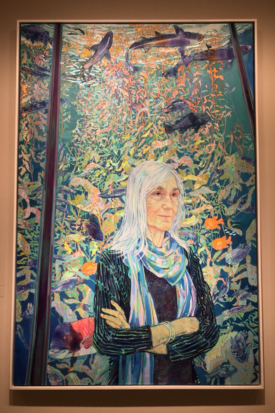photo of portrait in frame on display at Smithsonian National Portrait Gallery in DC: Artist: Hope Gangloff, born 1974 Sitter: Julie Packard, born 1953 2019 Painting, Acrylic on canvas Dimensions in frame: 212.1 × 141 × 6.4 cm (83 1/2 × 55 1/2 × 2 1/2") "Hope Gangloff, known for her colorful, stylized portraits, spent a week making sketches and photographs of Packard against the backdrop of the Monterey Bay Aquarium."