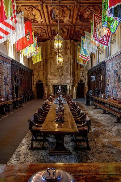 The grand dining room at Hearst Castle showcases opulent medieval decor with rich tapestries and impressive architecture.