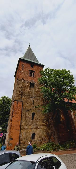 Andreaskriche in Verden met een toren die deels uit baksteen en deels uit natuursteen is opgetrokken, op de hoek een enorme steunbeer.